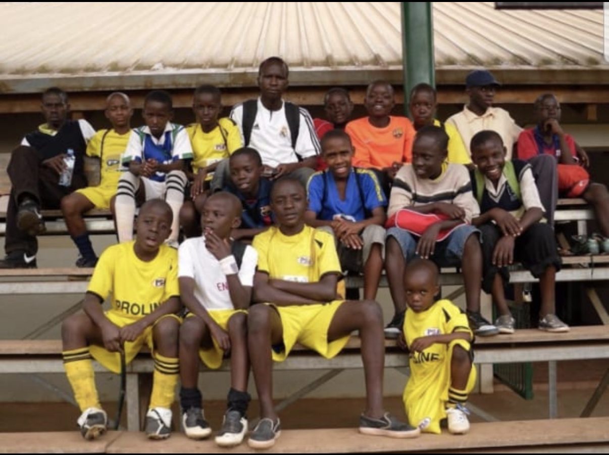 A youth soccer team in Uganda posing together on bleachers, the same sport that opened doors for Angello